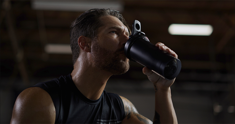 Man Drinking Water From a BlenderBottle Brand Shaker Cup